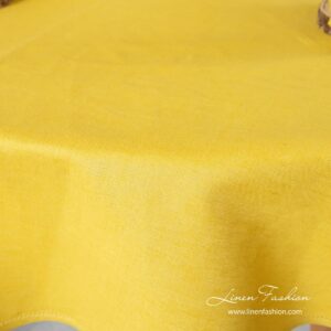 Yellow colored tablecloth, round.