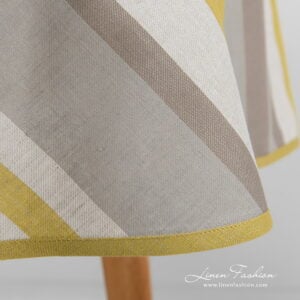 Linen round oval tablecloth striped with yellow piping.