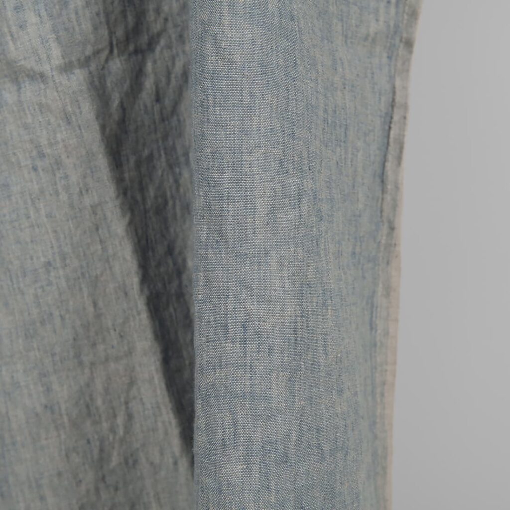 Linen washed fabric grayish blue color for sewing clothes and home textiles close edge view