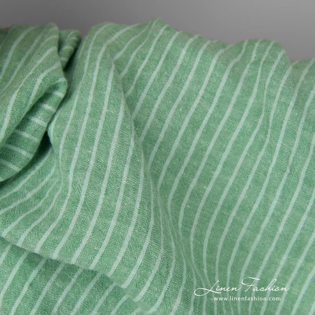 Wide washed green striped linen fabric close up detail view