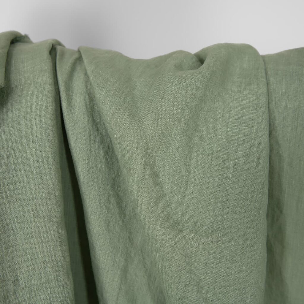 Washed linen fabric in muted light green, plain weave