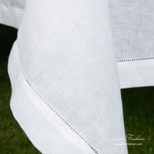 Border of white linen blend tablecloth with hemstitch