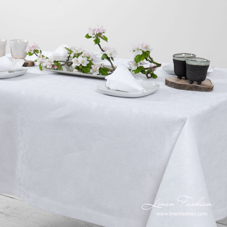 White linen tablecloth with flower ornaments, folded border