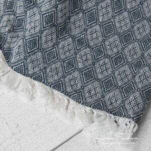 linen blanket with rhombus, with fringes on short sides.