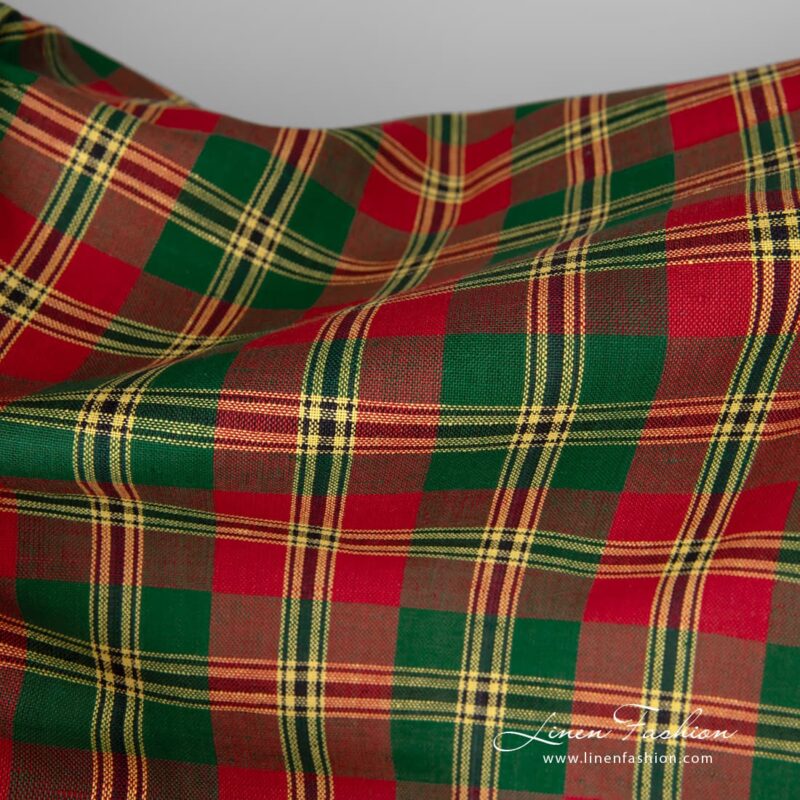 Linen / cotton fabric features a pattern consisting of criss-crossed horizontal and vertical bands of red, green and yellow colours
