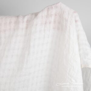 Off-white linen fabric in transparent checks, specially washed to increase softness