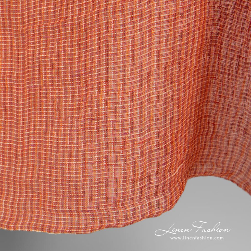 Linen fabric in melange, woven from orange, red and yellowish yarns